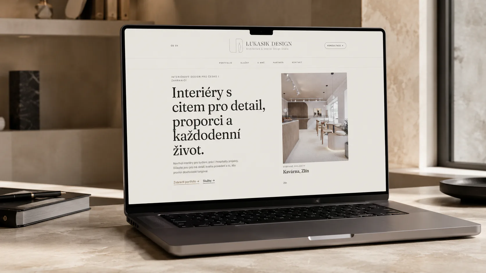 The Lukasik Design homepage open on a laptop: the studio claim on the left, a featured café project in Zlín on the right